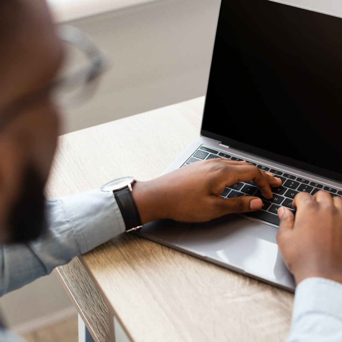 man typing on laptop