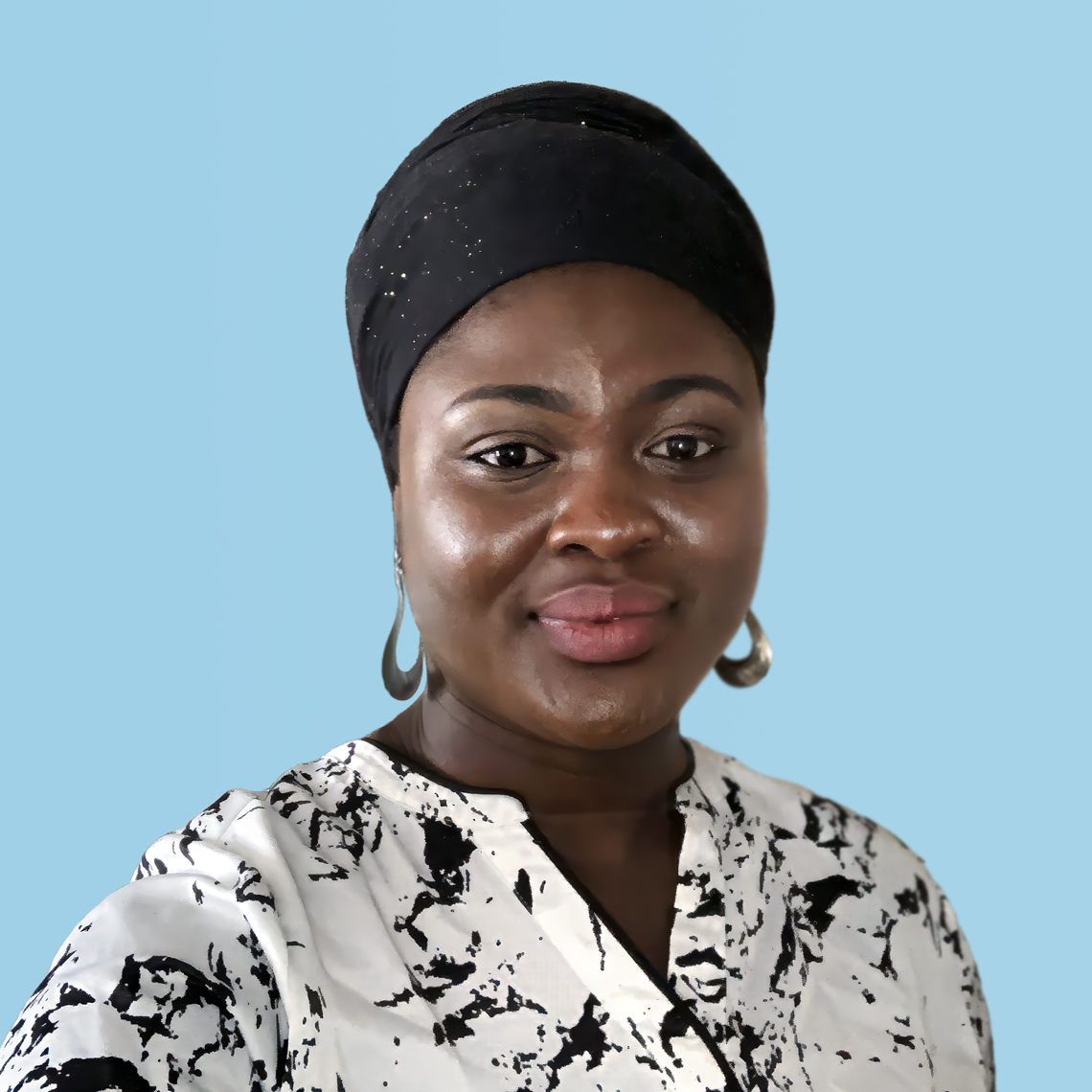 Hedayah Samali in black and white blouse against a light blue background
