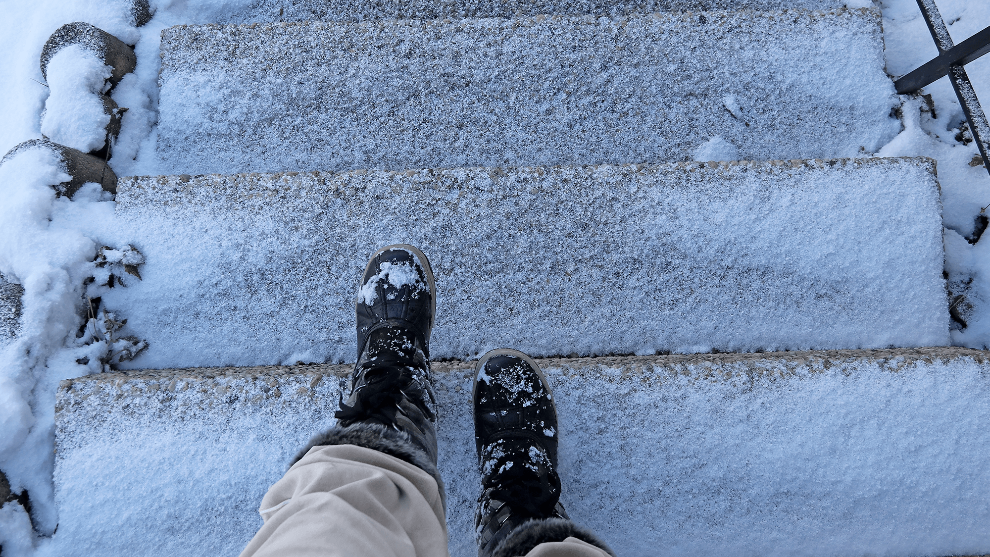 A person about to descend an icy set of stairs