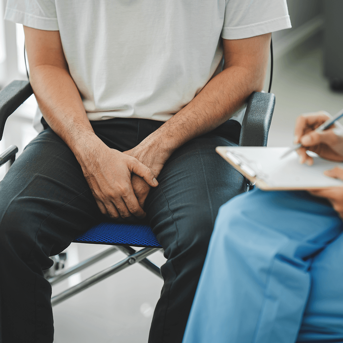 square image of bottom half of doctor and male patient sitting together