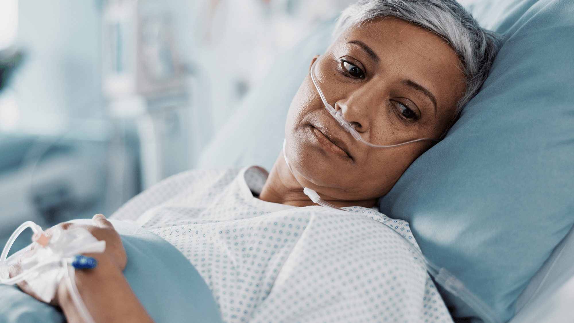 Middle aged woman with nasal feeding tube laying in hospital bed