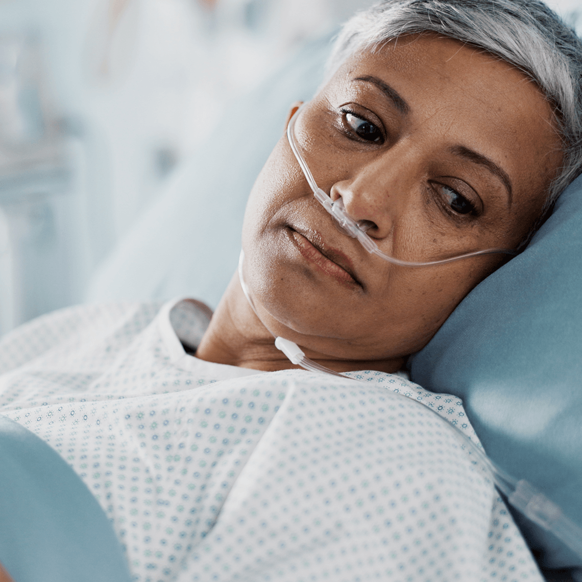 Middle aged woman with nasal feeding tube laying in hospital bed